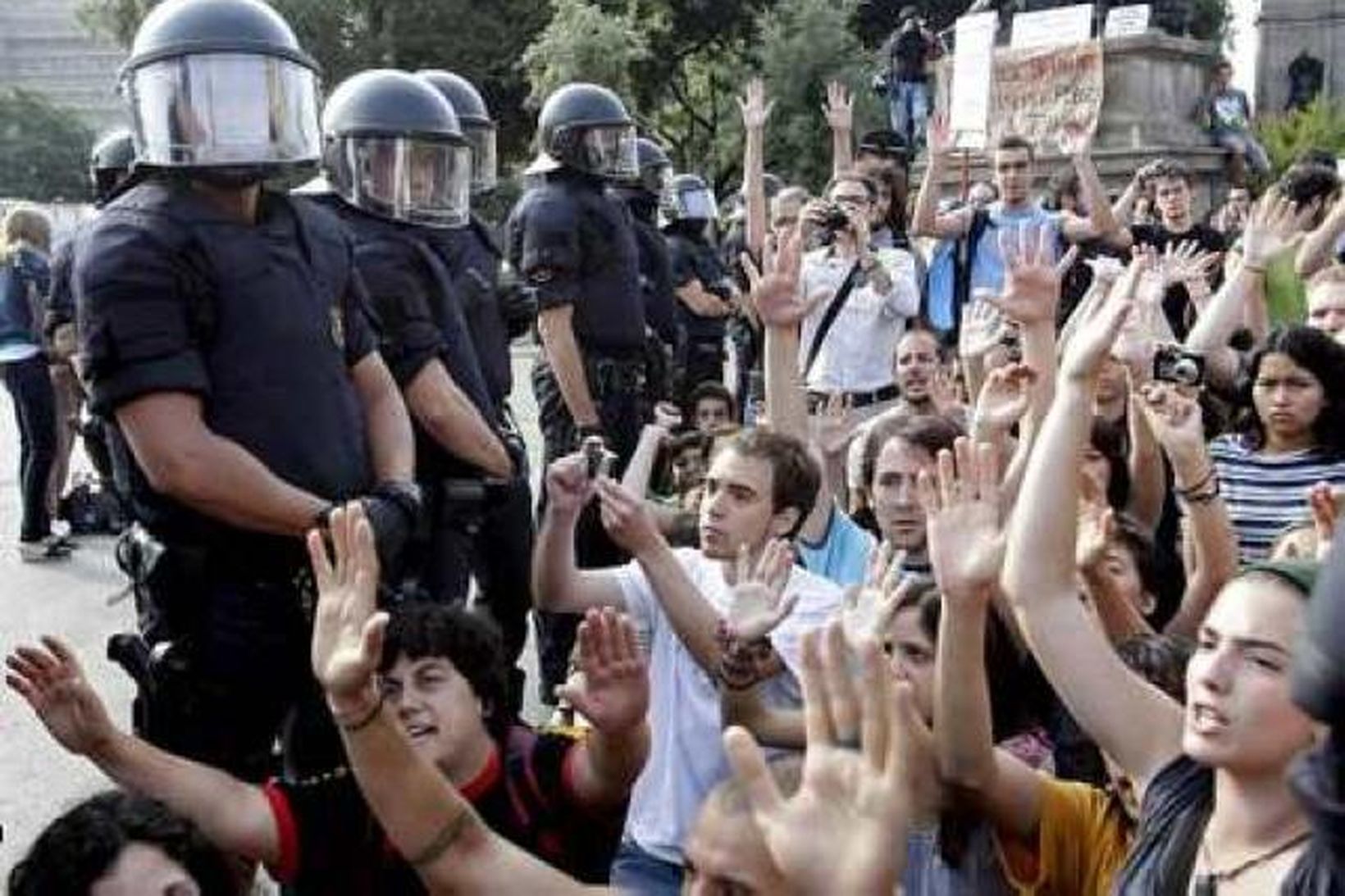 Lögreglumenn og mótmælendur á Plaza de Cataluna í Barcelona í …