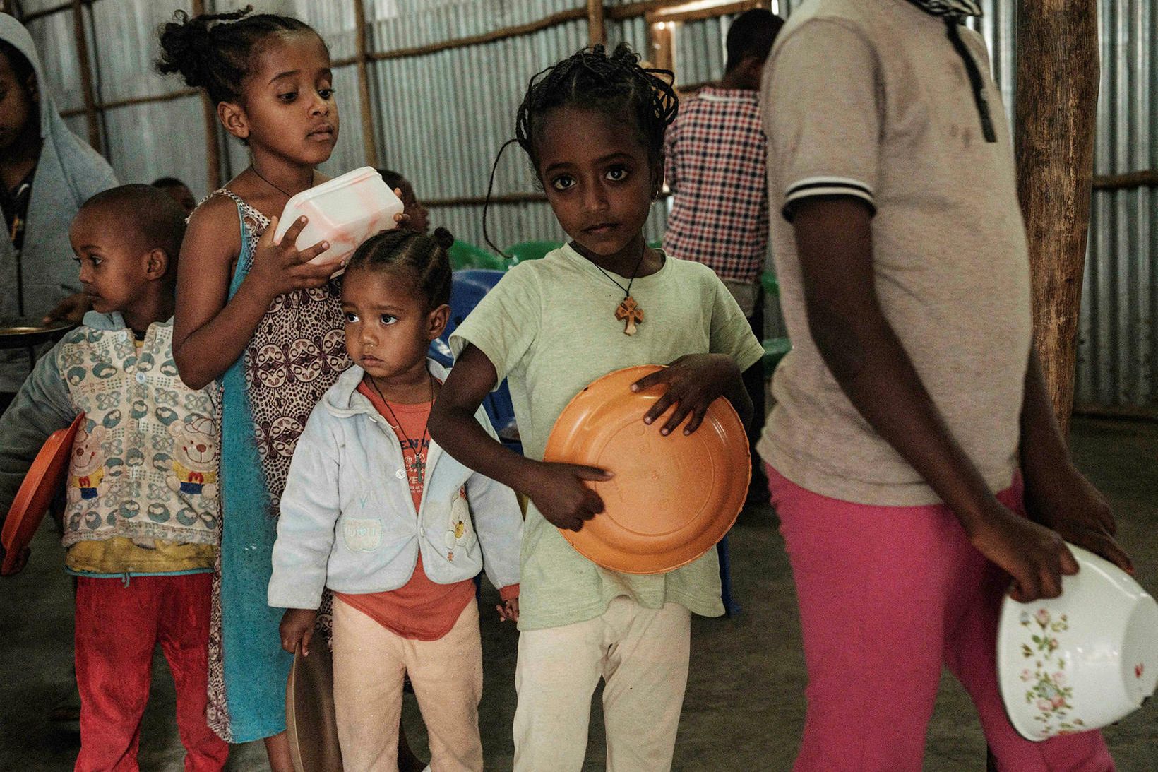 Börn á flótta undan átökunum í Tigray-héraði þiggja matargjöf.