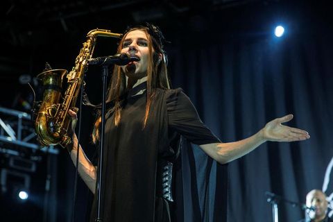 PJ Harvey dressed in black and wearing feathers on her head brandishing a saxofone at the Vodafone hall in Reykjavik last night.