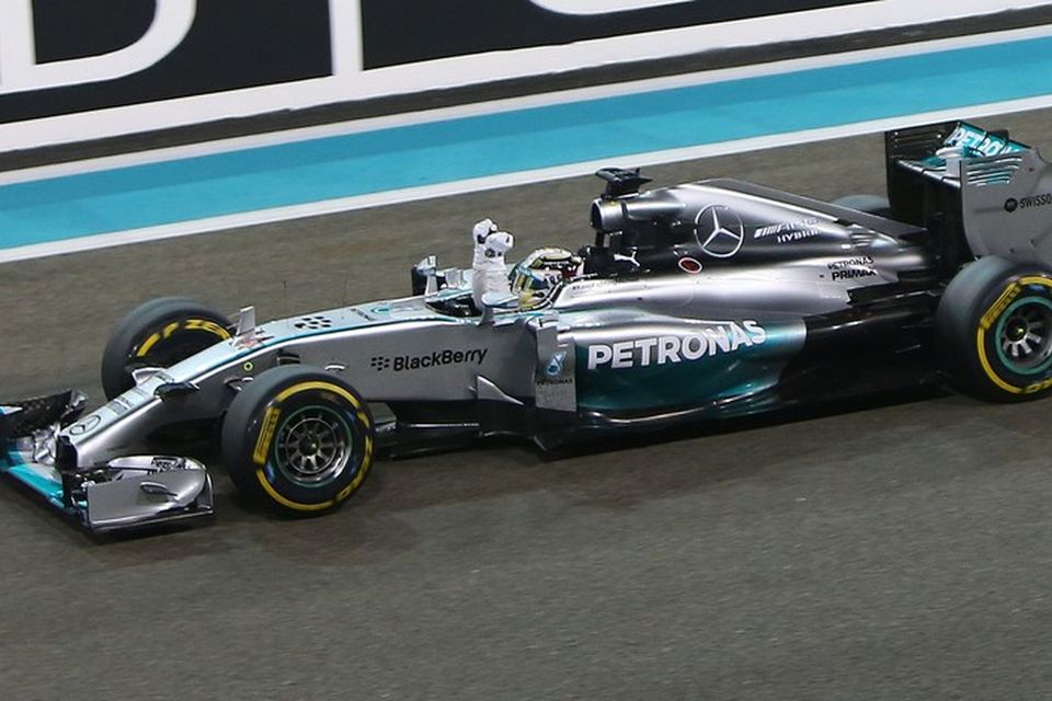 Lewis Hamilton ekur yfir marklínuna í Abu Dhabi sigri hrósandi. Annar heimsmeistaratitillinn í höfn.