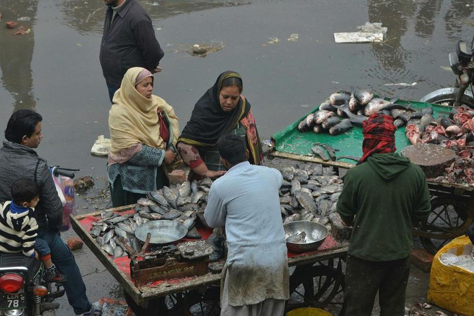 Íbúar í Lahore kaupa fisk á markaði. Töluvert er um …