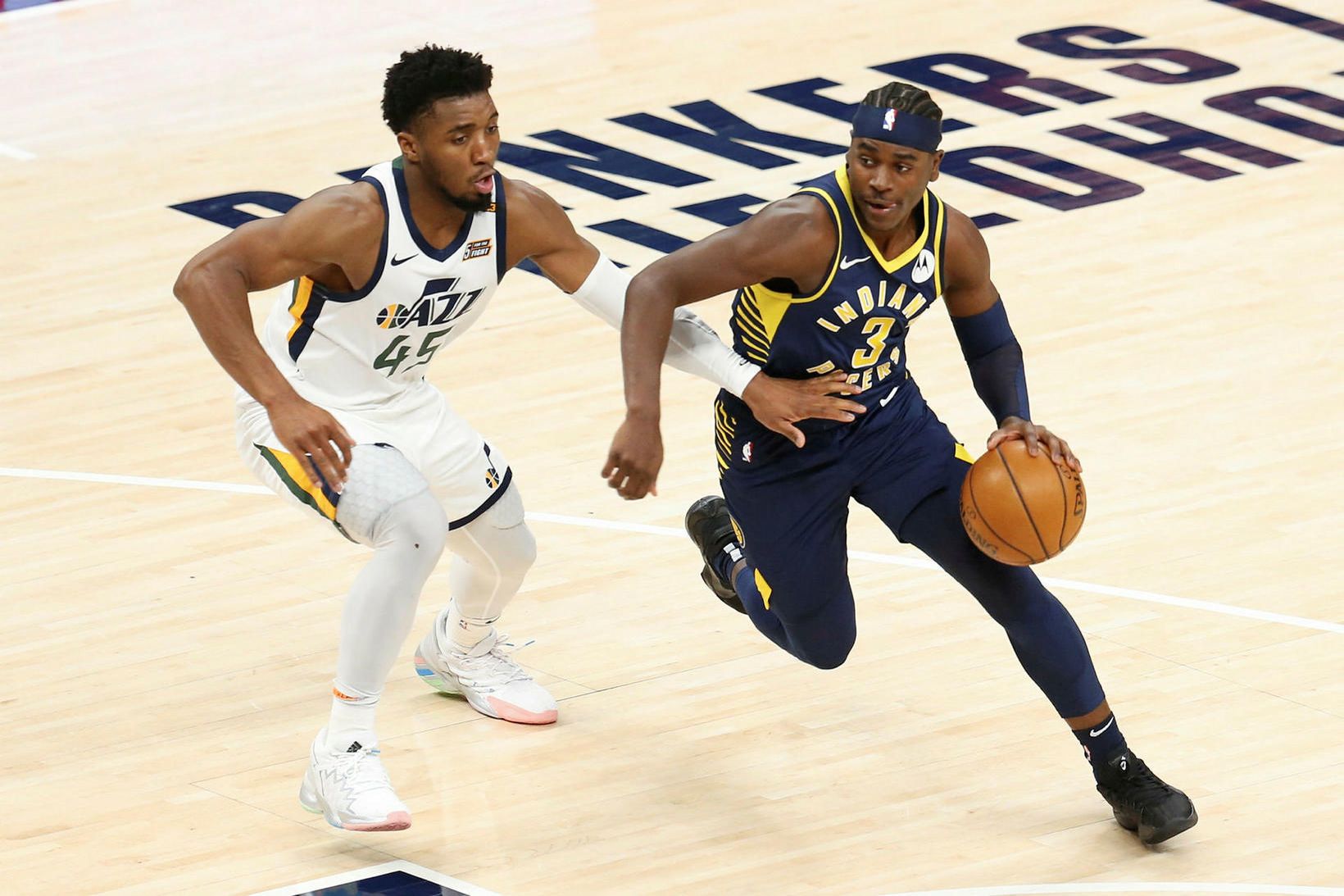 Donovan Mitchell í baráttu við Aaron Holiday í leiknum í …