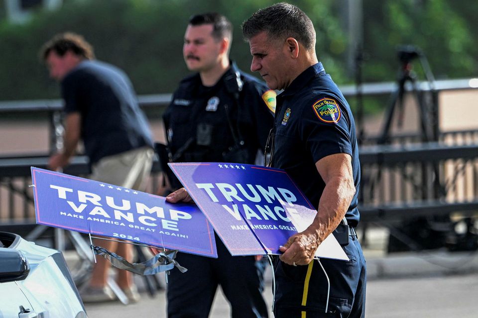 Lögreglumenn fjarlægja skilti til stuðnings Donald Trump, fyrrverandi forseta, nærri heimili hans í Mar-a-Lago í …