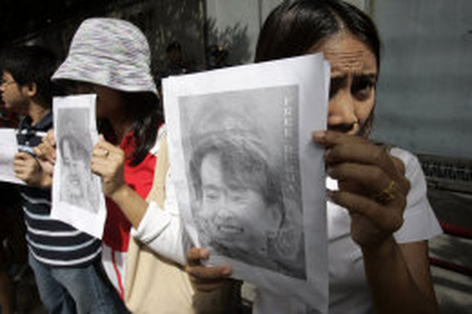 Mótmælendur halda á lofti myndum af Aung San Suu Kyi, …