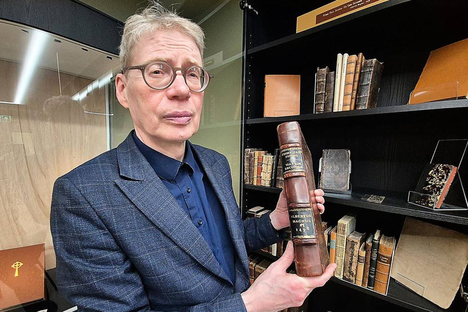 Kári Bjarnason, forstöðumaður Safnahúss Vestmannaeyja, í fágætissal safnsins með vögguprent …
