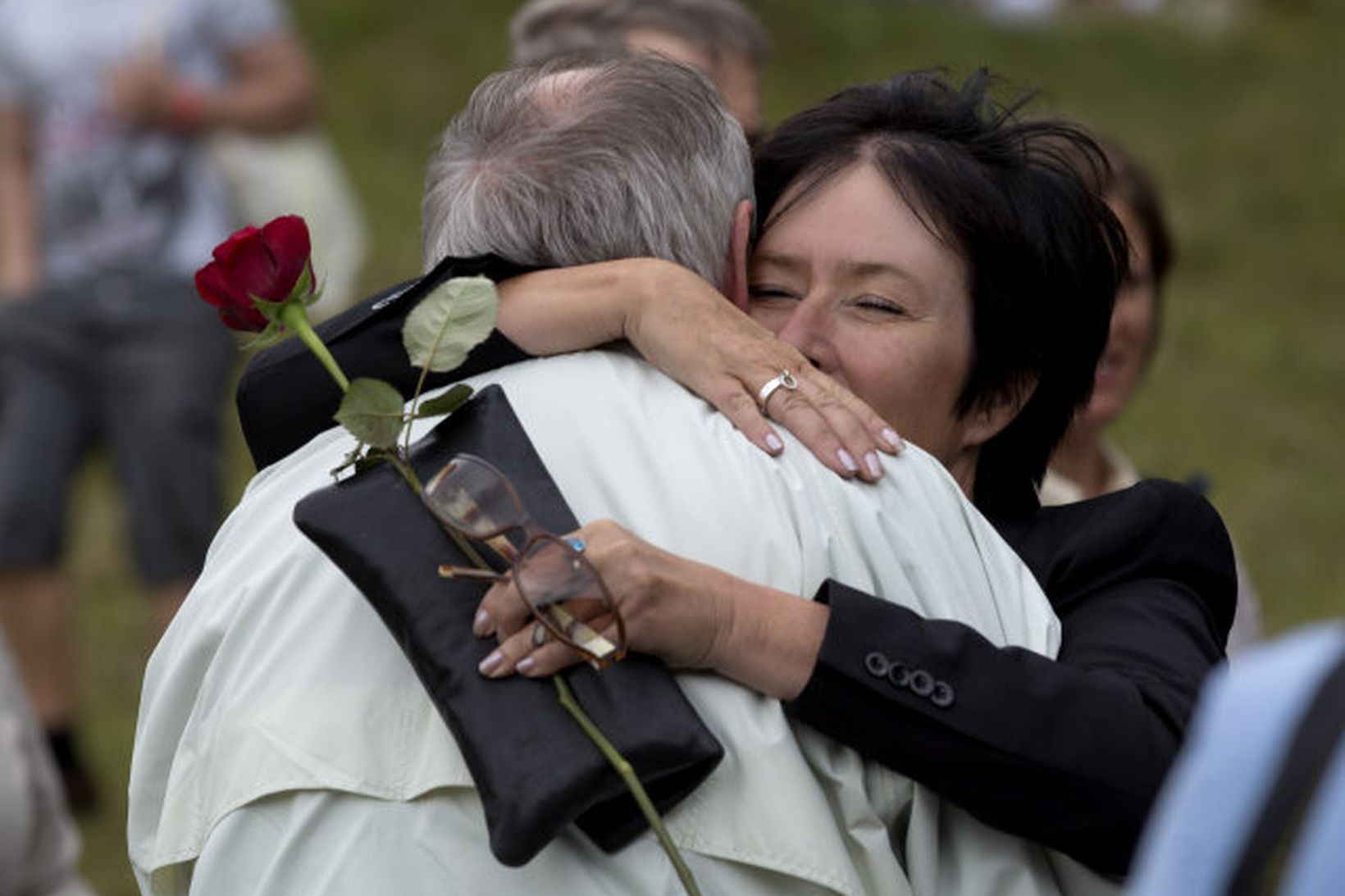 Þátttakendur í minningarathöfn í Útey 2012 fallast í faðma.