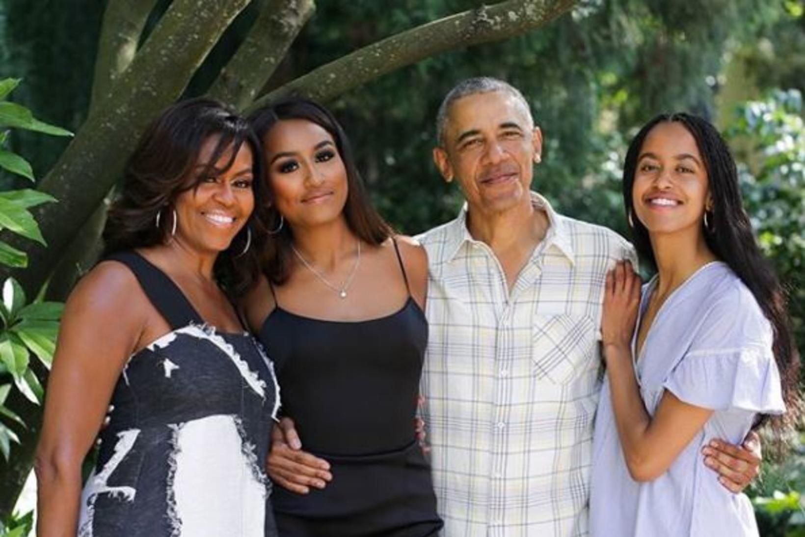 Sasha Obama stendur á milli foreldra sinna.