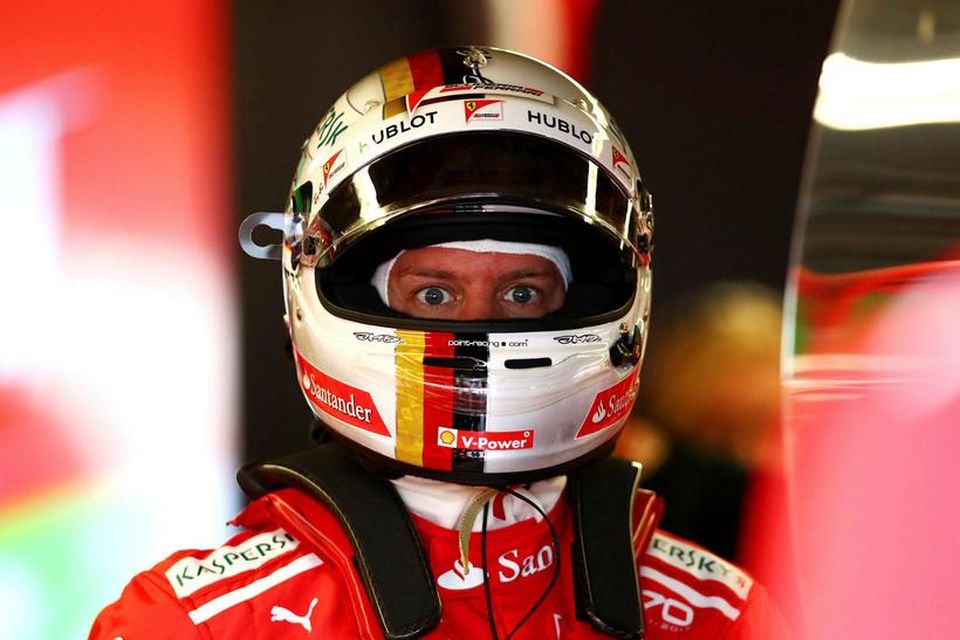 Sebastian Vettel undirbýr sig undir akstur í bílskúr Ferrari í Montreal.