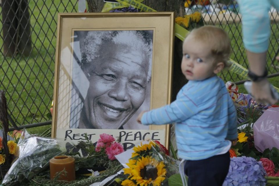 Lítið barn við mynd af Mandela eftir að tilkynnt var um andlát hans í gær.