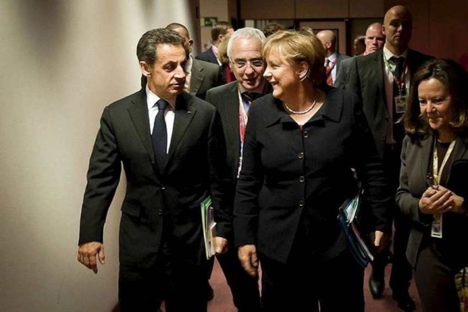 Germany's Chancellor Angela Merkel and France's President Nicolas Sarkozy (L) talk while on their way …