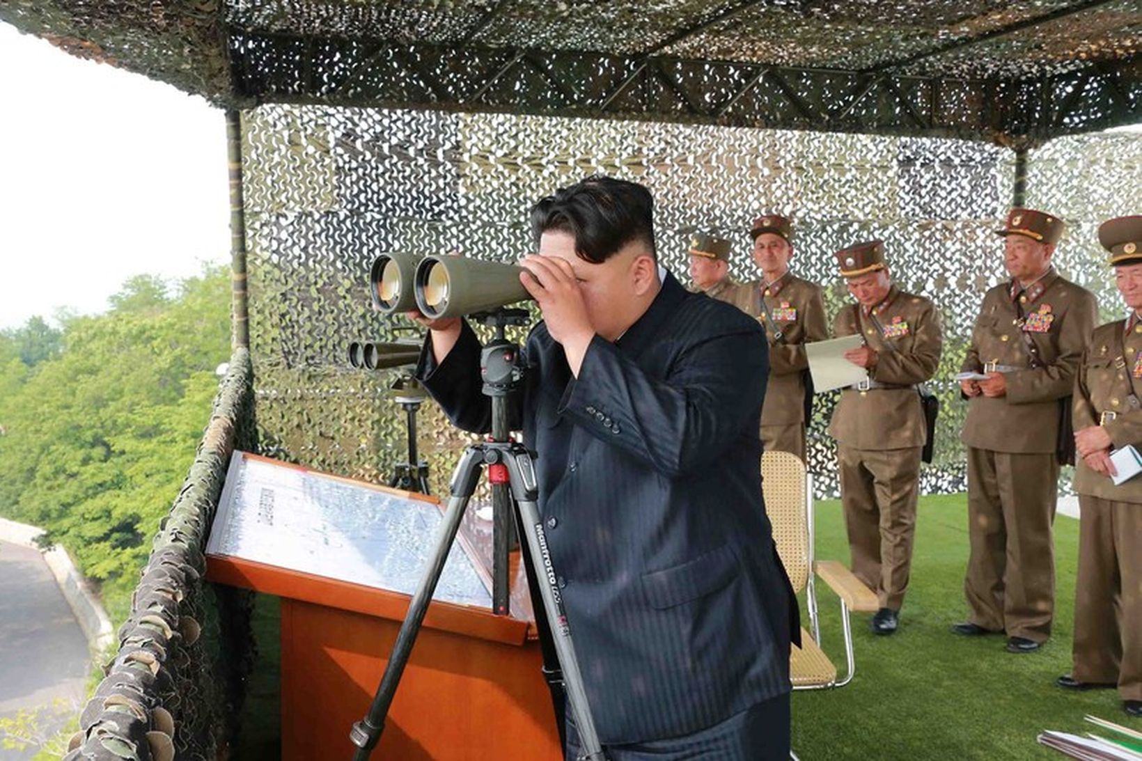 Kim Jong-un horfir gegnum sjónauka.