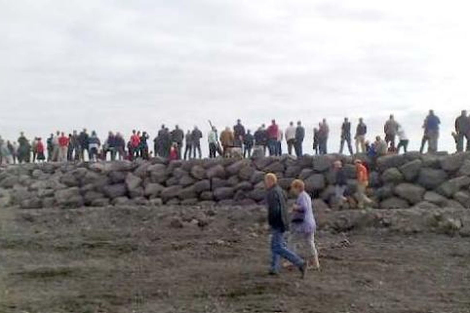 Margir stóðu á nýja hafnargarðinum og fylgdust með siglingu Herjólfs …