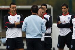Wayne Rooney hlýðir á Fabio Capello ásamt John Terry og Frank Lampard.