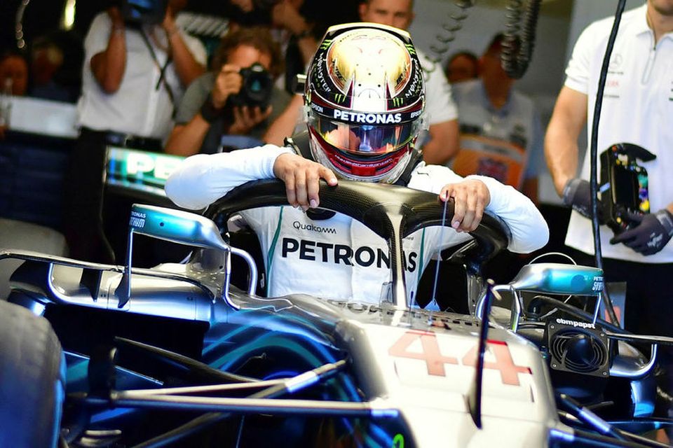 Lewis Hamilton fær sér sæti í Mercedesbílnum fyrir tímatökuna í Silverstone.