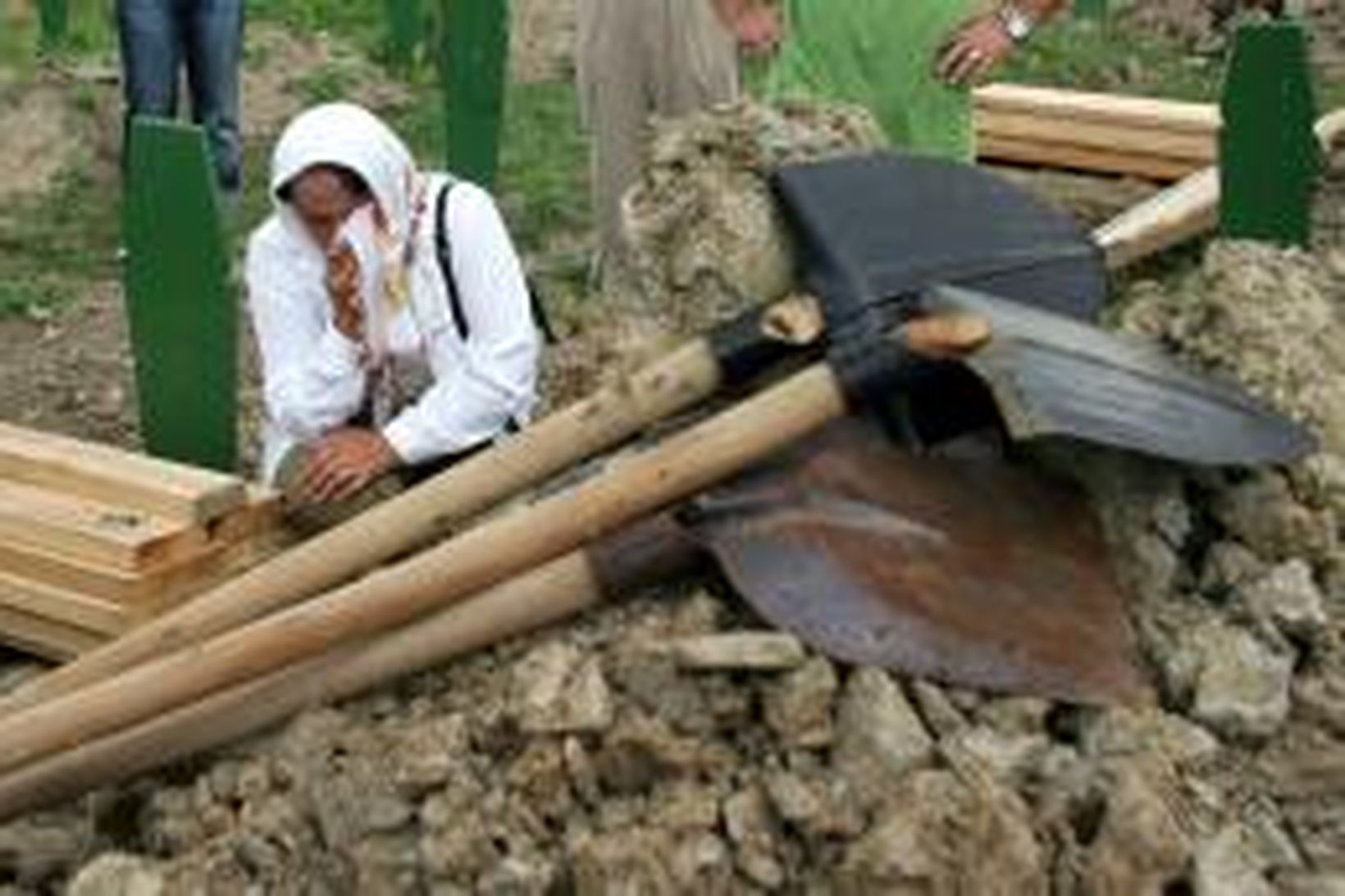 Koma grætur við gröf í Potocarií nágrenni Srebrenica.