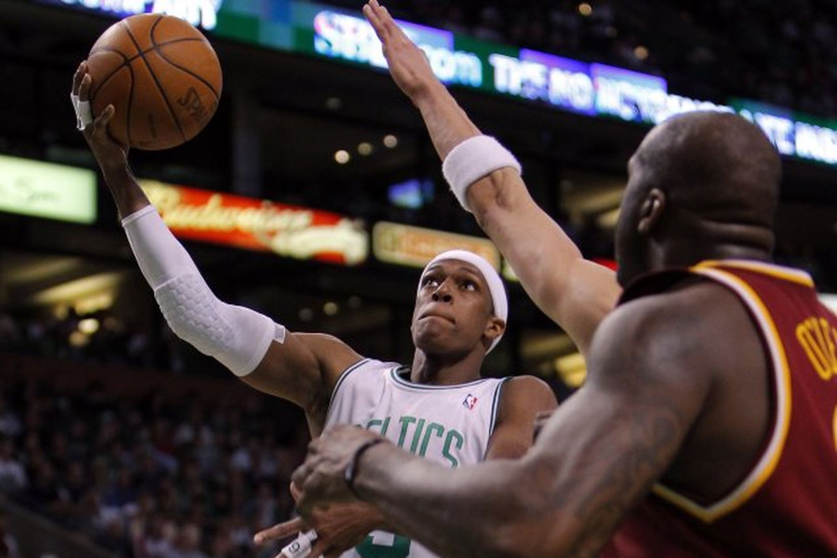 Rajon Rondo brunar að körfu Cleveland, framhjá Shaquille O'Neal.