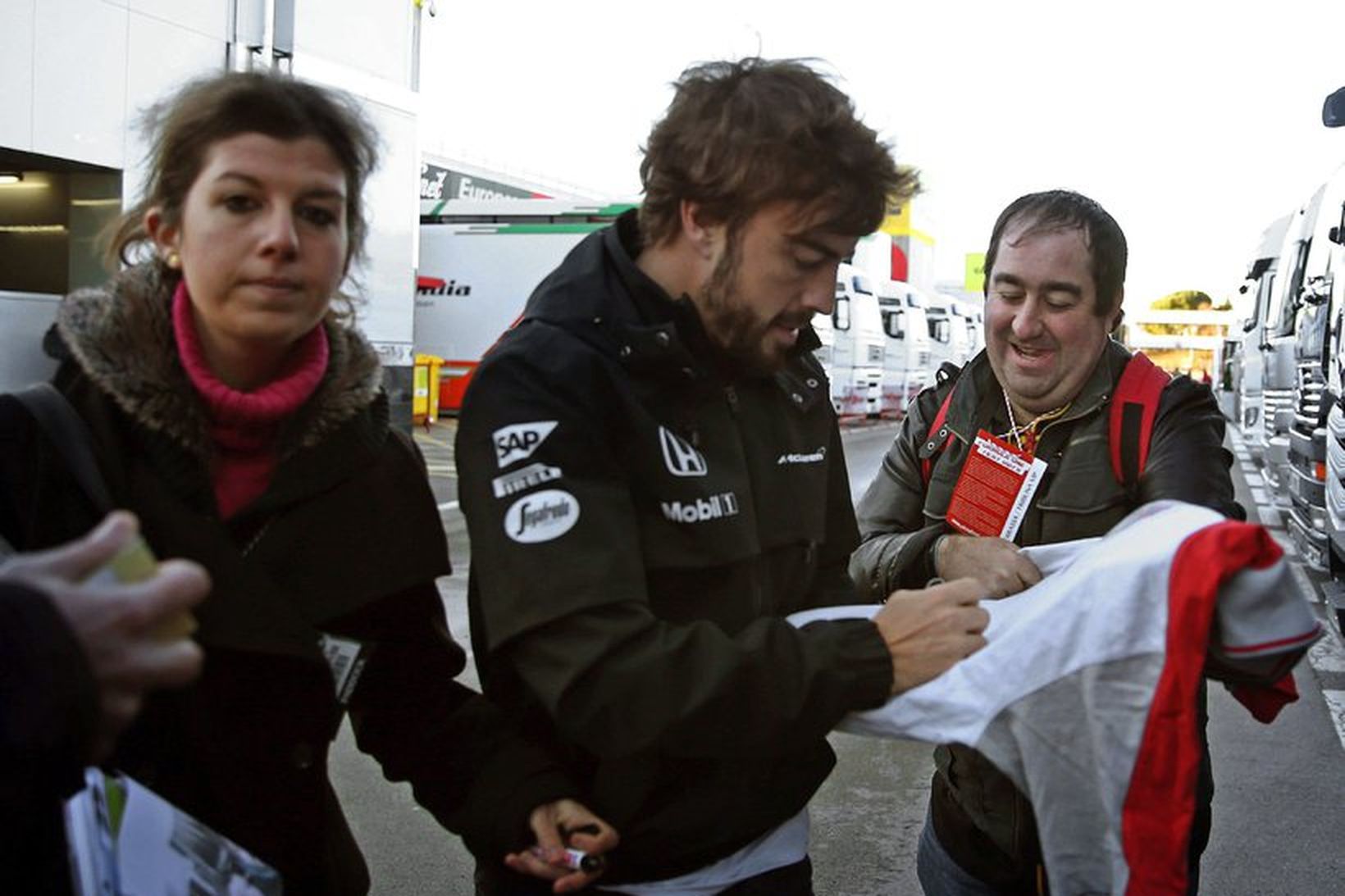 Fernando Alonso gefur aðdáanda eiginhandaráritun rétt fyrir upphaf æfingaaksturs hans …