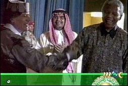 Gaddafi og Mandela handsala samkomulag um að sá fyrrnefndi muni framselja þá er grunaðir eru …