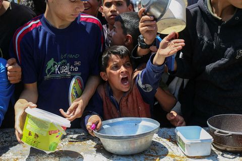 Palestínskur piltur sést hér kalla er hann bíður eftir að fá mat sem góðgerðarsamtök gáfu …
