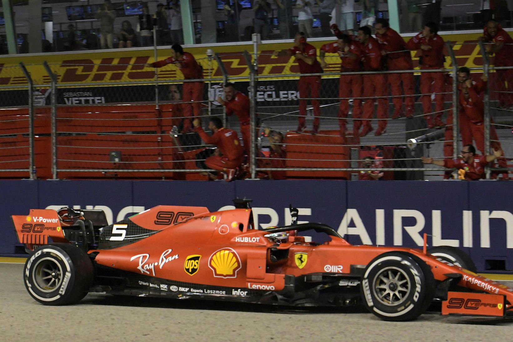 Liðsmenn Ferrari fagna Sebastian Vettel við marklínuna í Singapúr.
