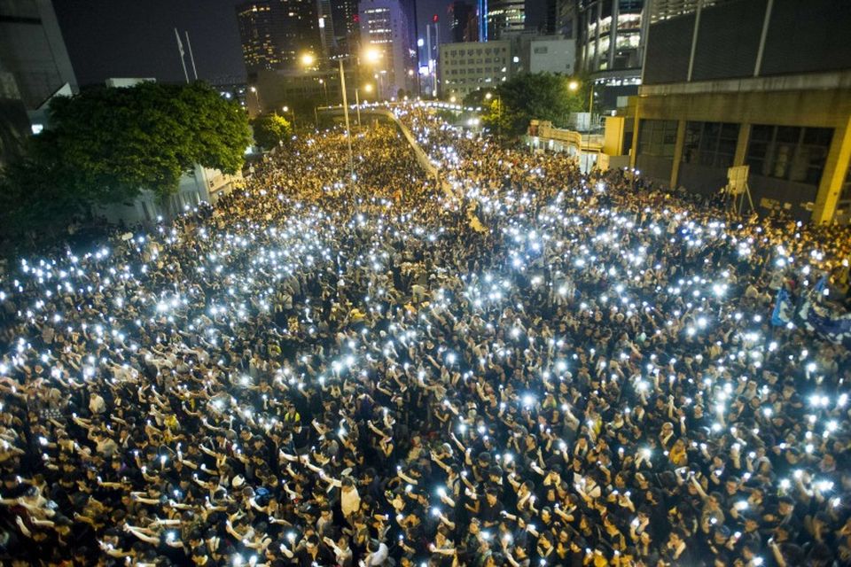 Mótmælendur í Hong Kong halda á lofti símum sínum til að sýna samstöðu fyrir utan …