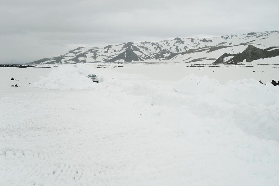 Bifreiðin á myndinni virkar smá í snjógöngunum sem búið er að moka. Þau geta fyllst …