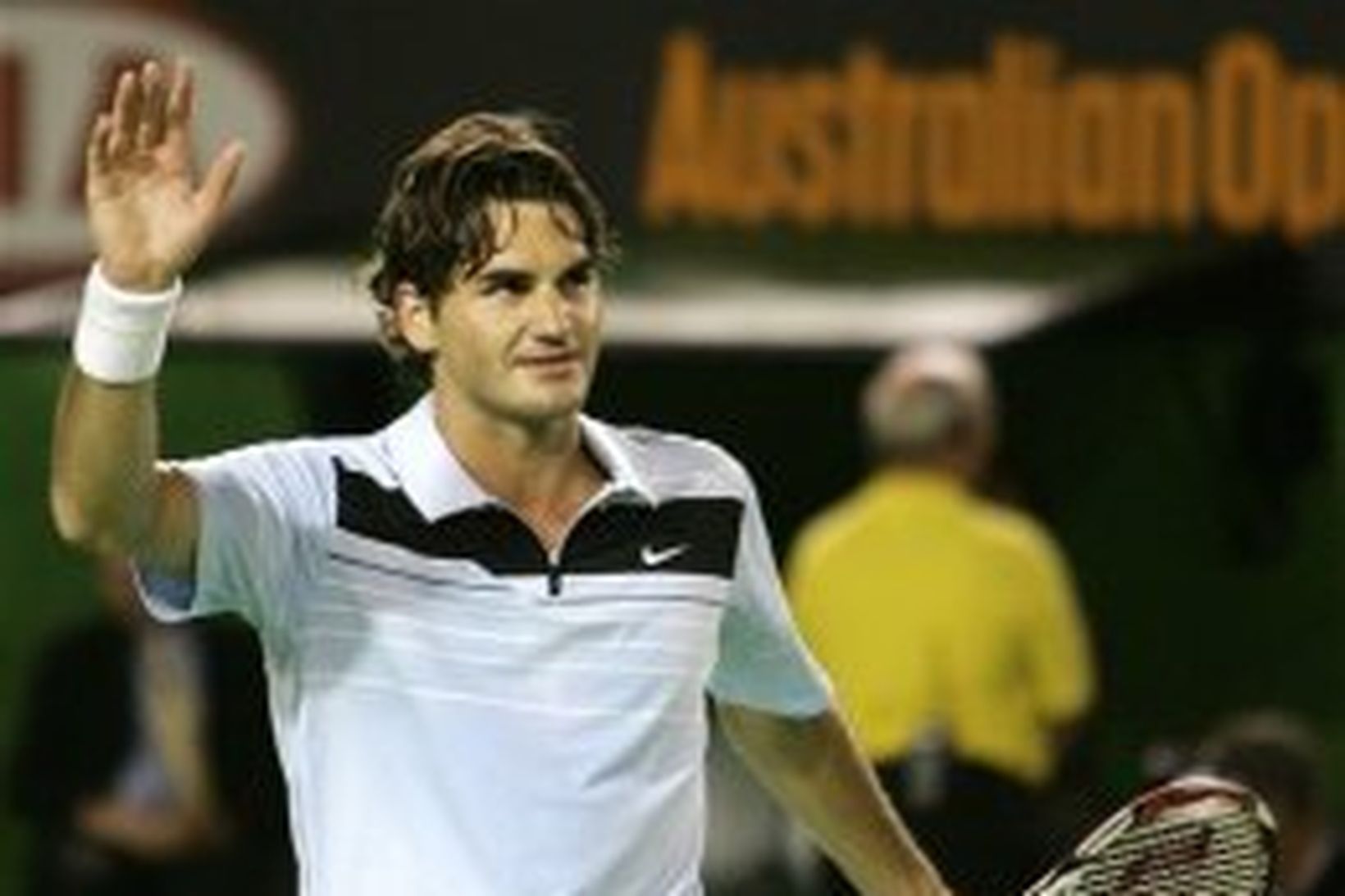 Roger Federer veifar til áhorfenda í Melbourne í morgun.