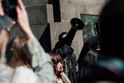 Grímuklæddur mótmælandi No Borders mætti með gjallarhorn og reyndi að drekkja ræðuhöldum í hávaða.