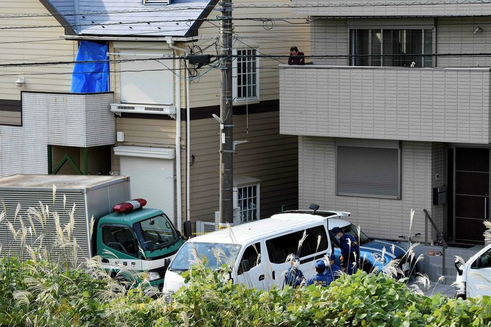 Japanska lögreglan að störfum fyrir utan fjölbýlishúsið sem maðurinn bjó …