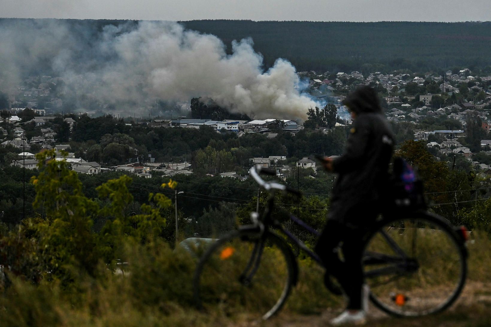 Hjólreiðarmaður horfir á borgina Izium í Kramatorsk í austurhluta Úkraínu.