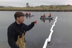 Starfsmenn Slökkviliðs höfuðborgarsvæðisins leggja flotgirðingu yfir Elliðavog.