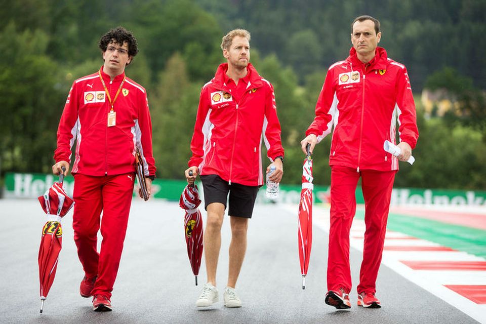 Sebastian Vettel (fyrir miðju) skoðar brautina í Speilberg í Austurríki ásamt nokkrum vélfræðingum sínum. Regnhlífar …