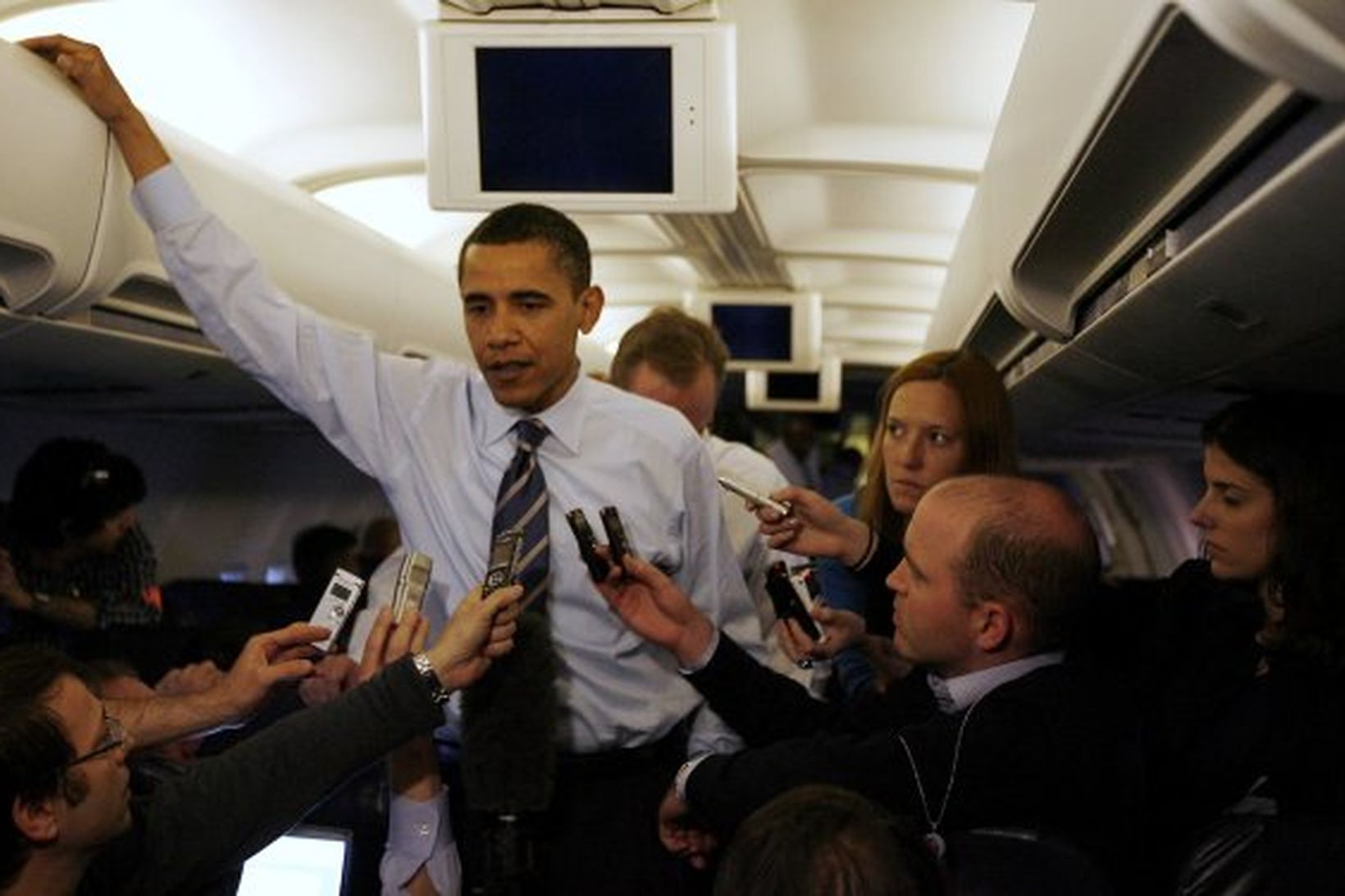 Barack Obama ræðir við blaðamenn um borð í flugvél.