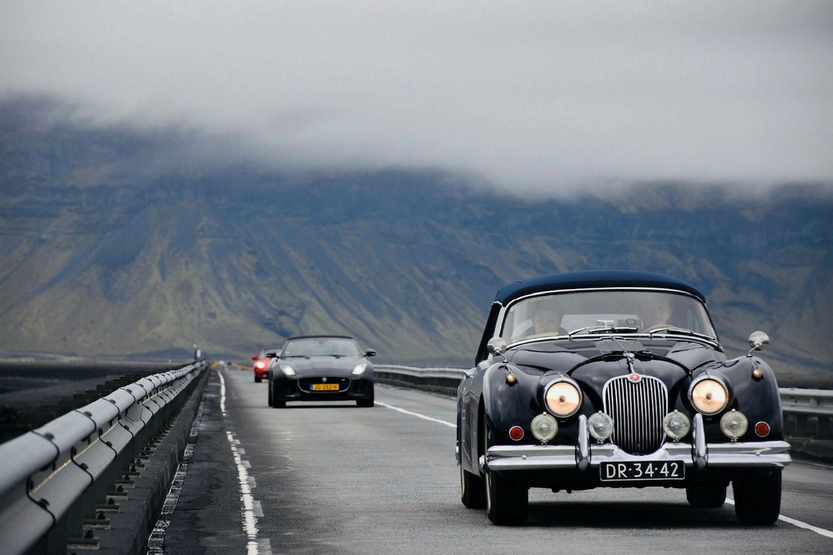 Jaguar XK150DHC, árgerð 1960 á gráum en hrífandi sumardegi. Bílaframleiðandinn …