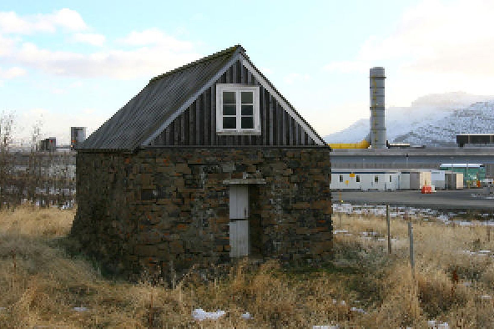 Sómastaðahúsið. Álver Alcoa Fjarðaáls er í baksýn.