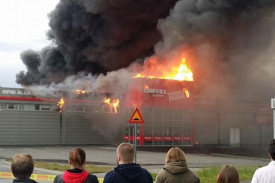 Fjölmargir, hundruð manna, fylgjast með húsunum í Skeifunni brenna.