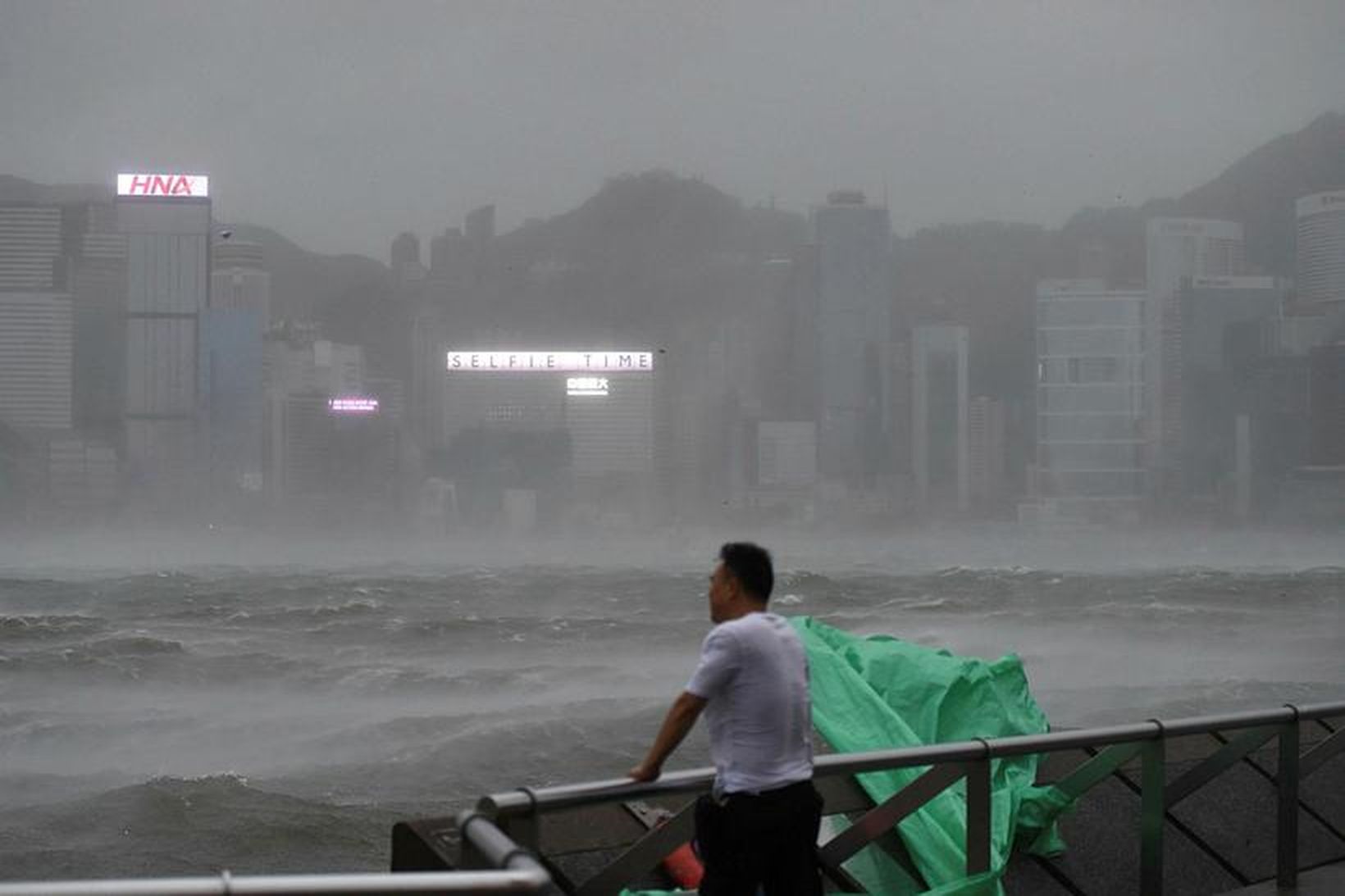 Maður horfir yfir höfnina í Hong Kong.