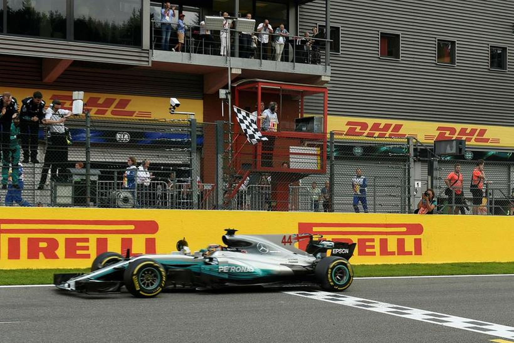 Sigurfánanum veifað er Lewis Hamilton ekur yfir endamarkið í Spa-Francorchamps …