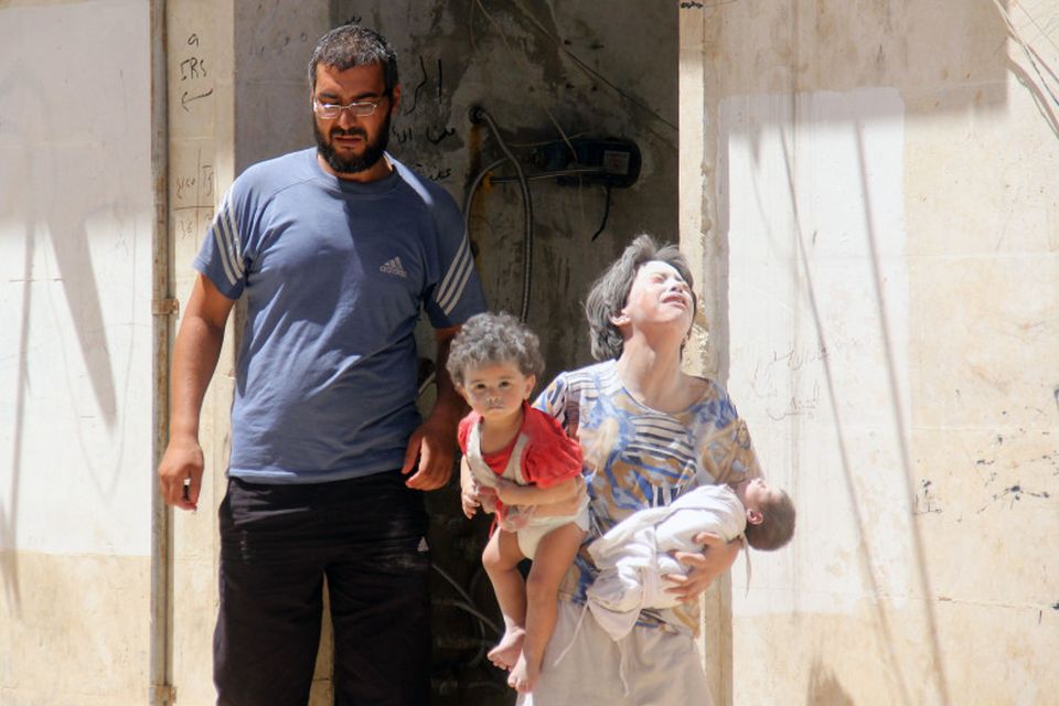 Sýrlensk fjölskylda yfirgefur heimili sitt eftir loftárásir í borginni Idlib.