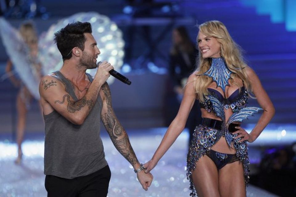 Adam Levine söngvari Maroon 5 tekur í hönd kærustu sinnar, Anne Vyalitsina sem er fyrirsæta …