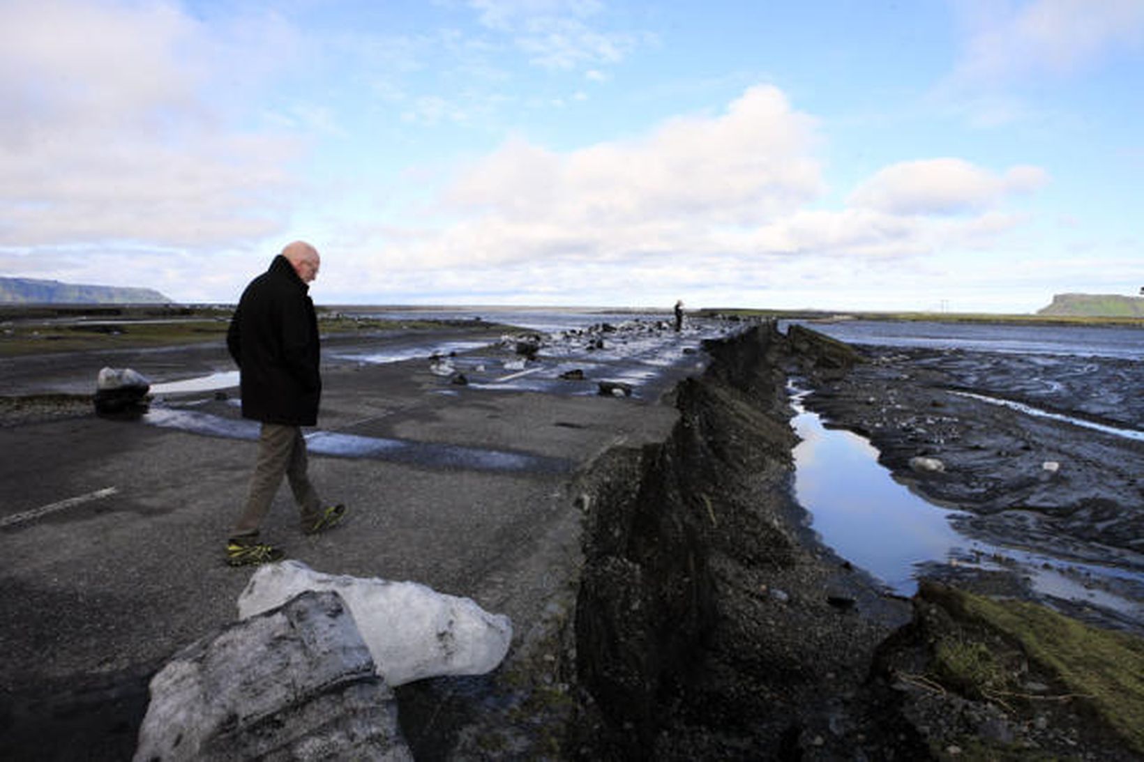 Steingrímur J. Sigfússon fjármálaráðherra skoðar skemmdirnar á vegnum við Múlakvísl.