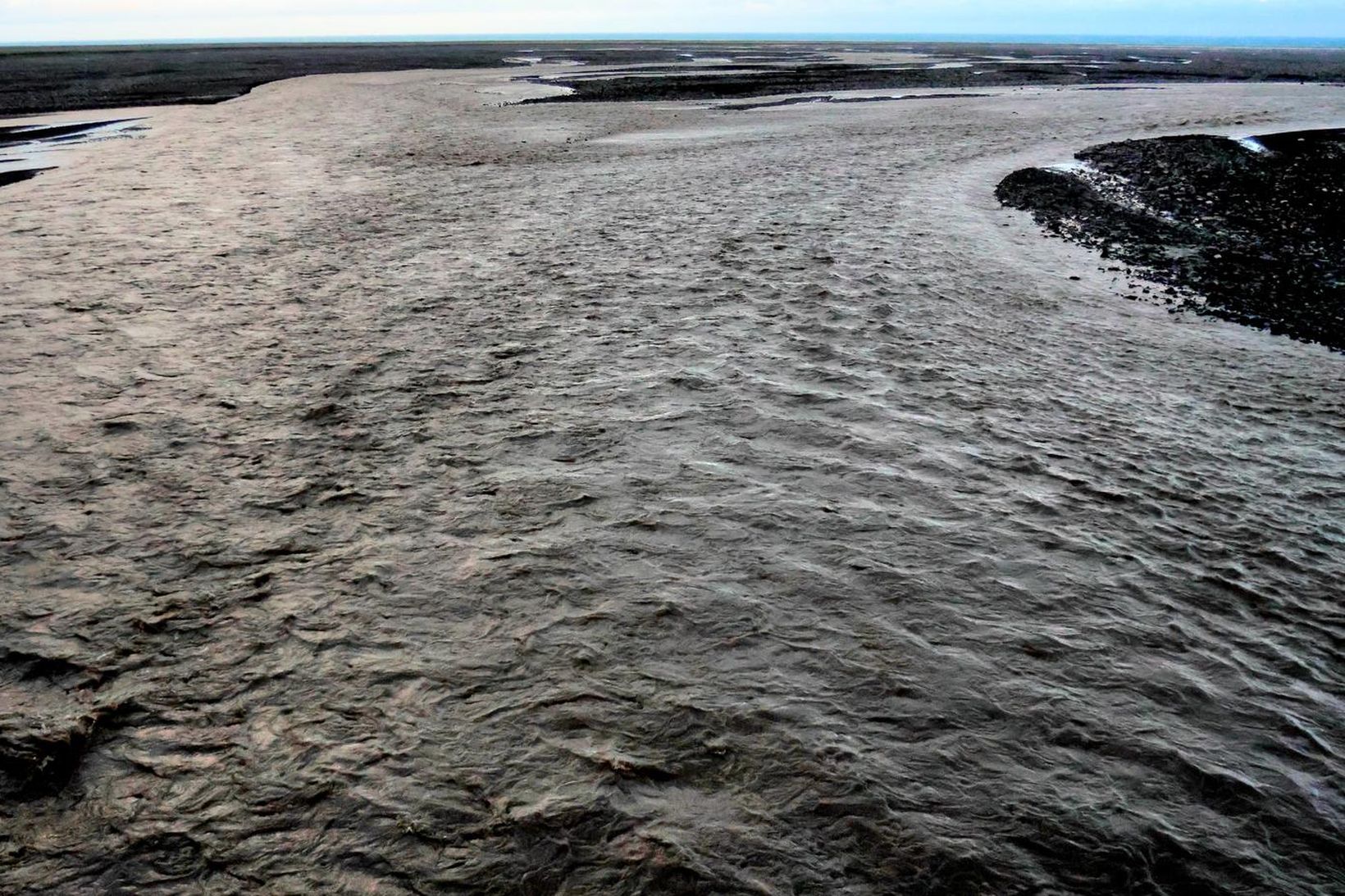 Áin er vatnsmeiri og skítugri en undanfarið, að sögn íbúa …