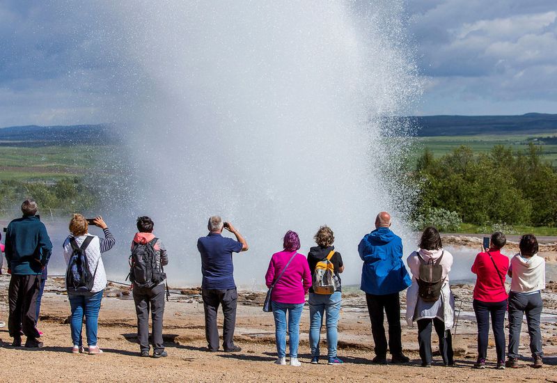 Tourists by Strokkur, South Iceland.