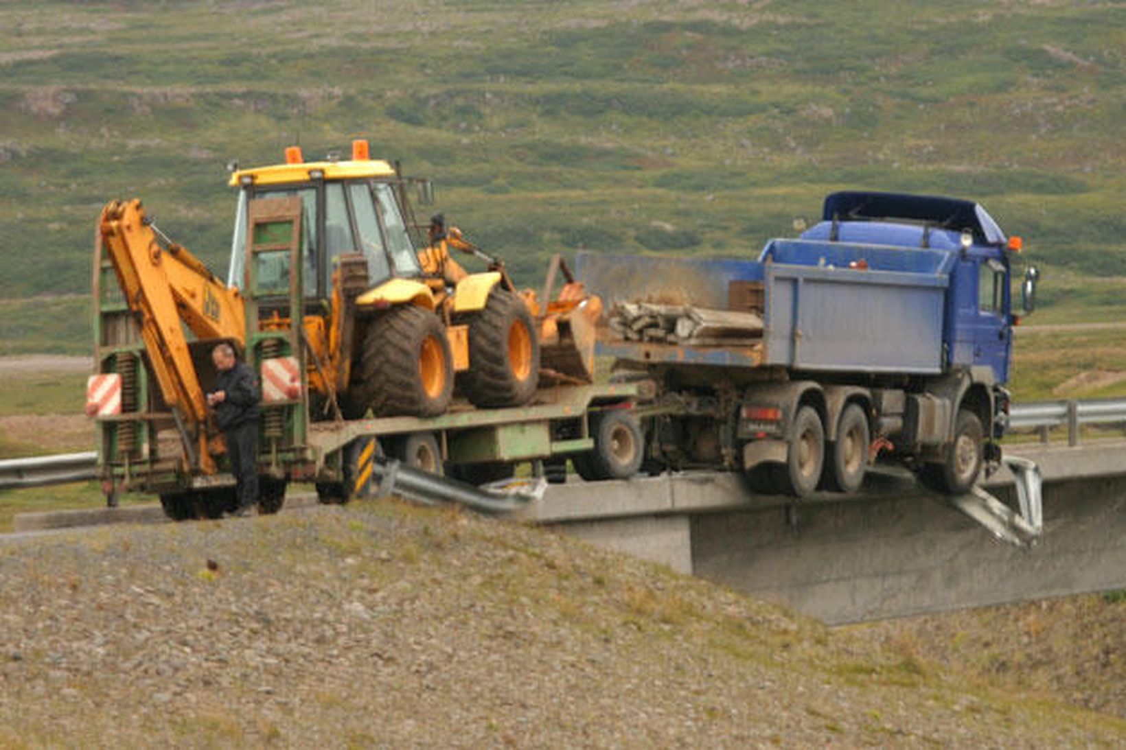 Unnið að því að losa vörubílinn af brúnni.