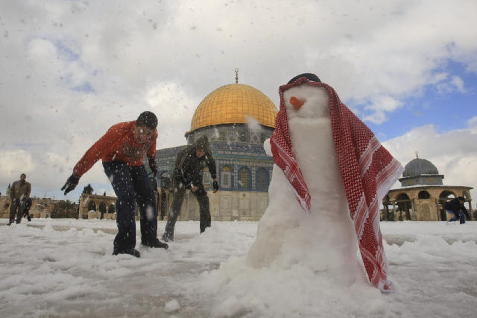 Palestínsk börn búa til snjókarl í nágrenni Al-Aqsa moskunnar í …