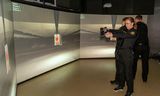 Lögreglunemar munda lasertengdar Glock-skammbyssur í hermi menntasetursins.