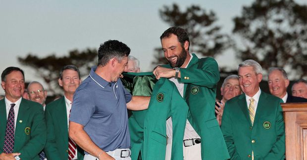 Scottie Scheffler klæðir Rory McIlroy í græna jakkann í gær. Scheffler er efsti kylfingur heimslistans …