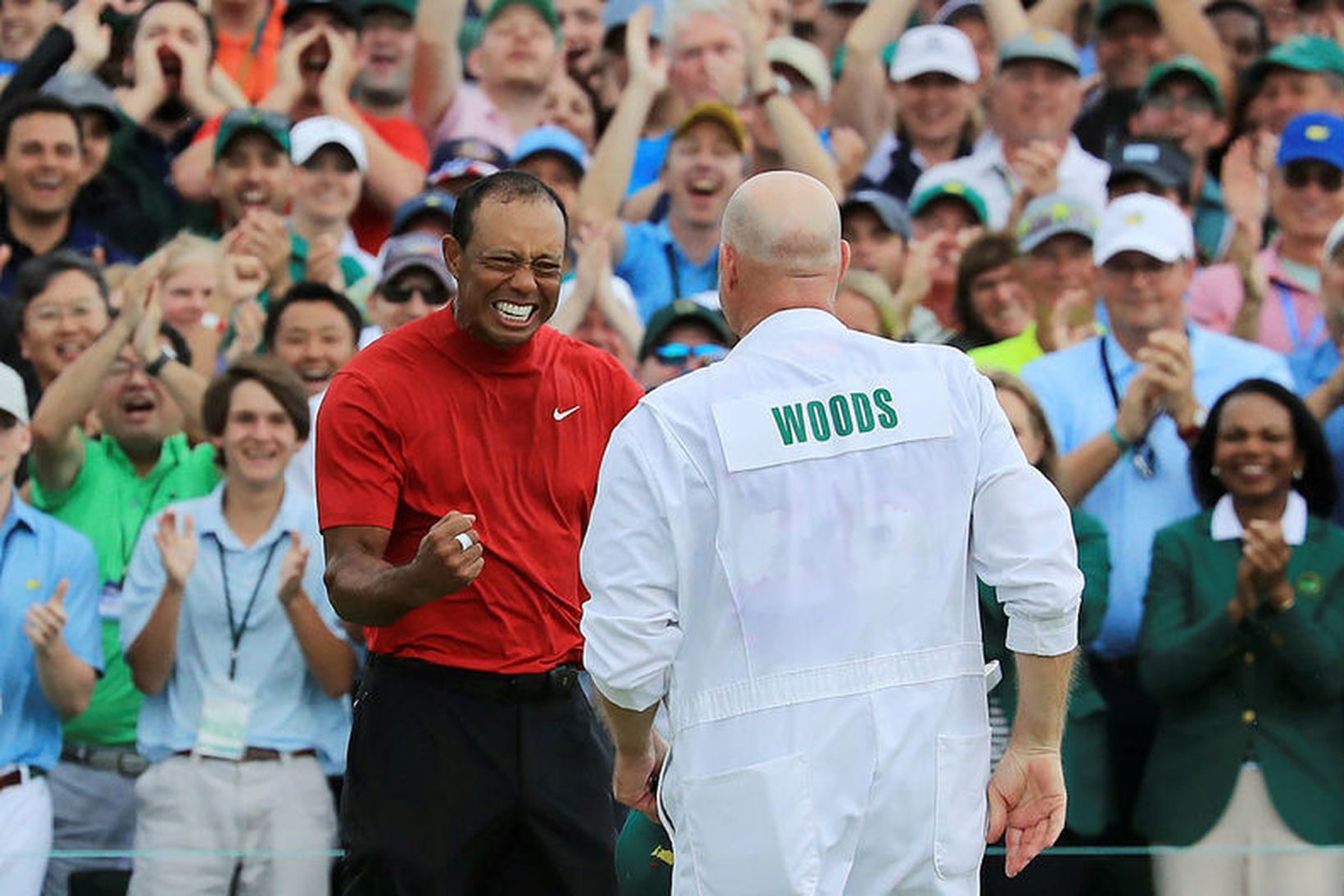 Tiger Woods fagnar með kylfusveini sínum.