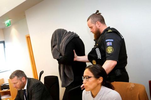 Thomas Møller Olsen covering his face from photographers at the Reykjanes district court today.