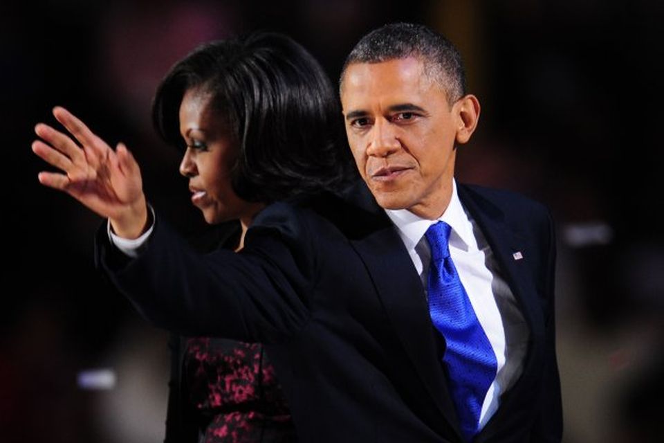 Barack Obama veifar til stuðningsmanna sinna. Eiginkonan Michelle við hlið hans á sviðinu.